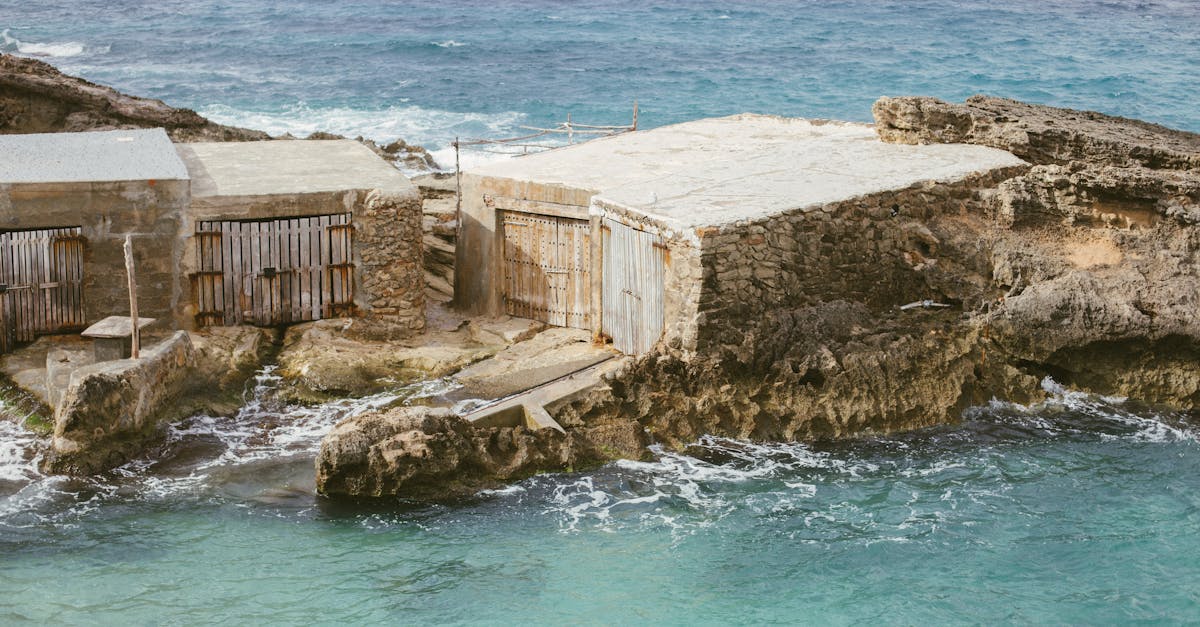 weathered fishermen s sheds by the azure sea in ibiza spain showcasing rustic coastal charm