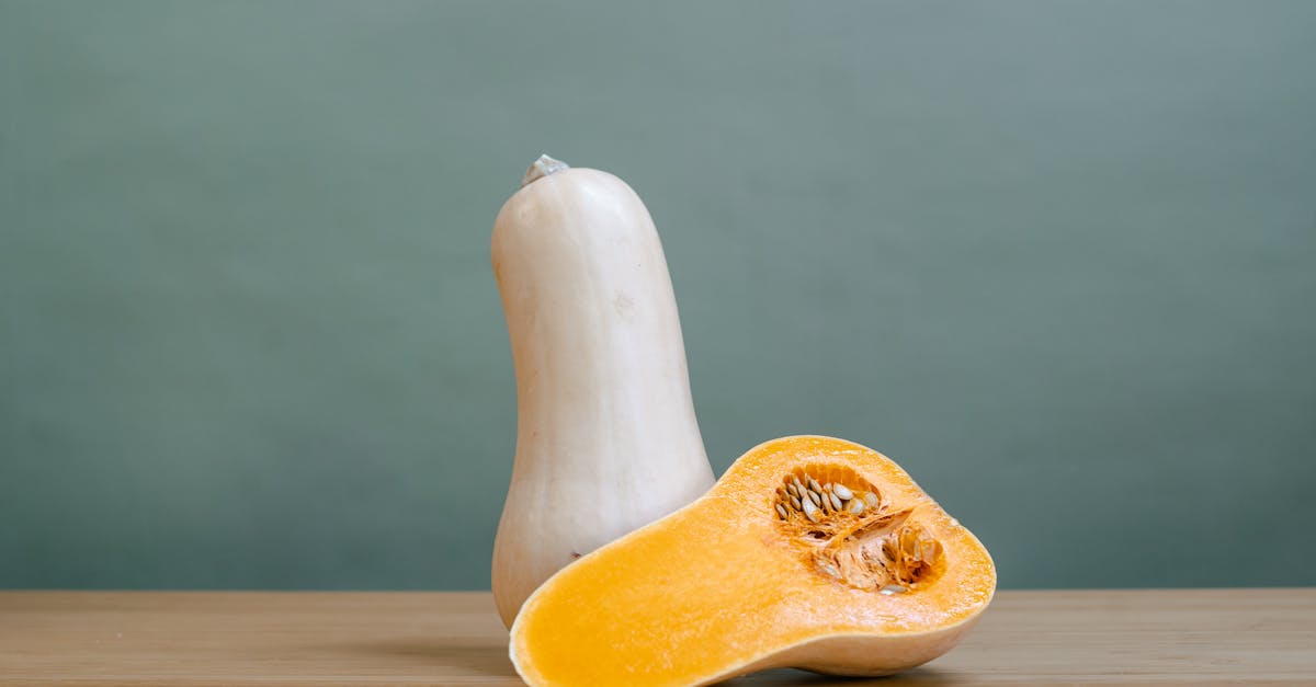 whole and halved butternut squash on a wooden table with a soft background 4