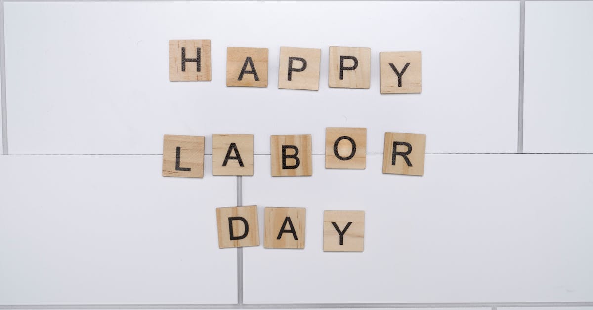 wooden letter tiles spelling happy labor day on a white tile background